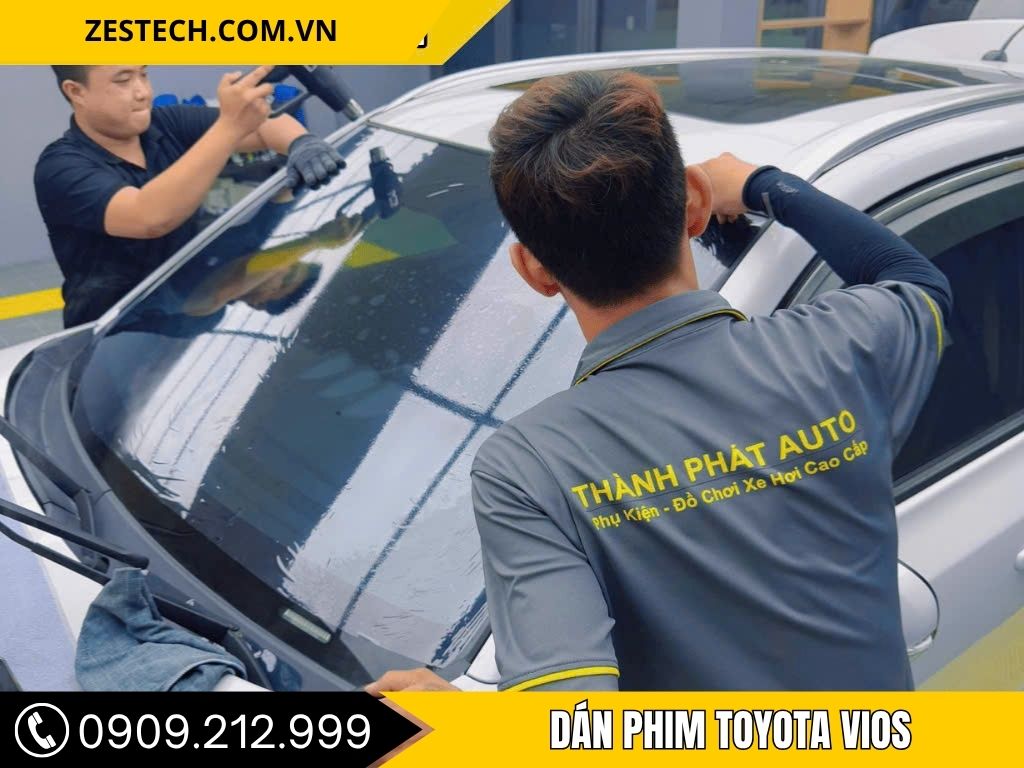 các kỹ thuật viên đang dán phim cách nhiệt cho xe Toyota vios tại trung tâm phụ kiện ô tô tại Bình Dương